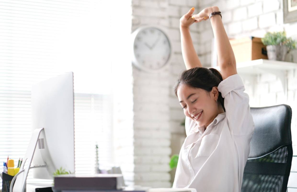 women sitting at her desk stretching